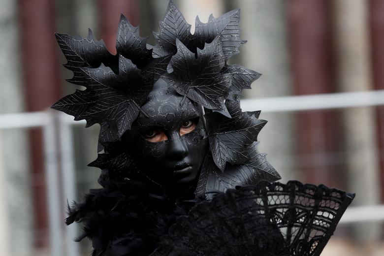 Một người đeo mặt nạ phủ đen tham gia Lễ hội hóa trang Venice ở Venice, Italy