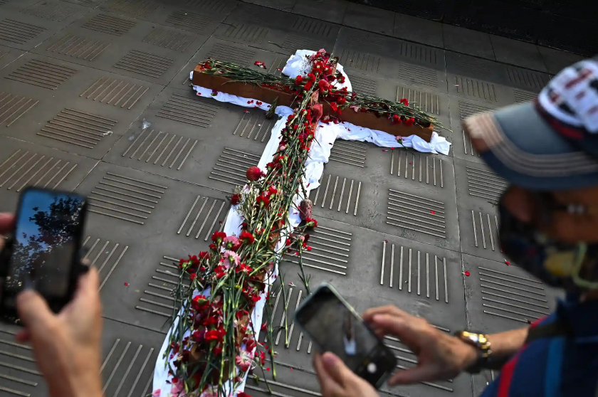 Kito hữu tại Sydney đang xếp các cánh hoa thành hình chữ thập - Ảnh:  Anadolu Agency/Getty Images.