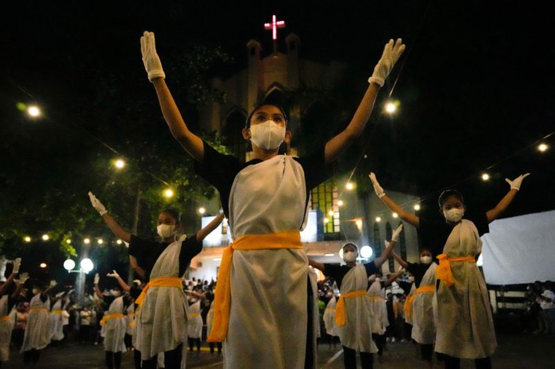Cô gái đeo khẩu trang đang trình diễn nghi lễ Phục Sinh tại Philippines - Ảnh: AP.