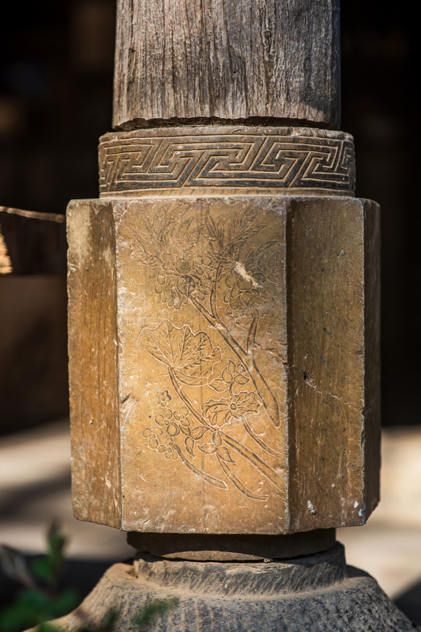 Chân trụ bằng đá được chạm khắc hoa văn thể hiện cuộc sống của người Giáy.  