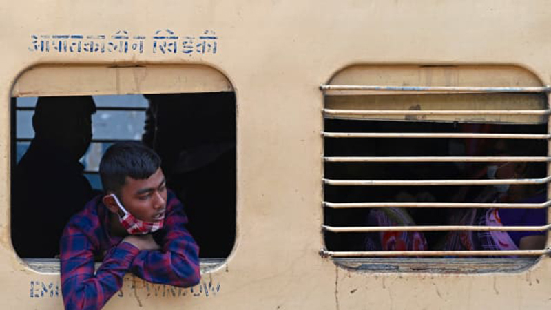 Một hành khách nhìn qua cửa sổ một chuyến tàu đường dài tại nhà ga ở Mumbai - Ảnh AFP/Getty