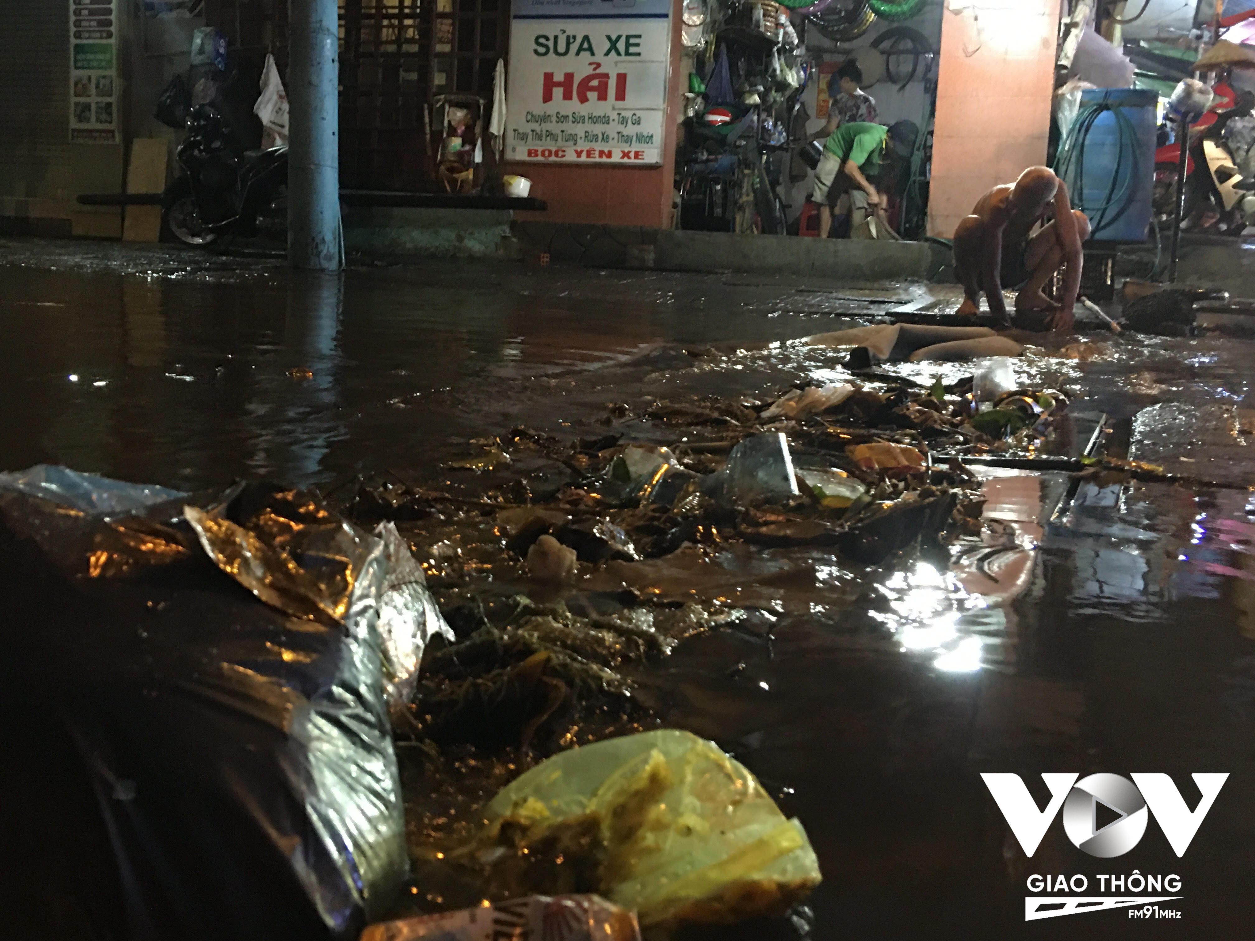 Đang lội nước để móc rác dưới cống thoát nước lên, ông Lập (81 tuổi, ngụ phường Phước Bình) cho biết, hiện đường số 8 đang nâng cấp sửa chữa đến 4 tháng vẫn chưa thi công xong.