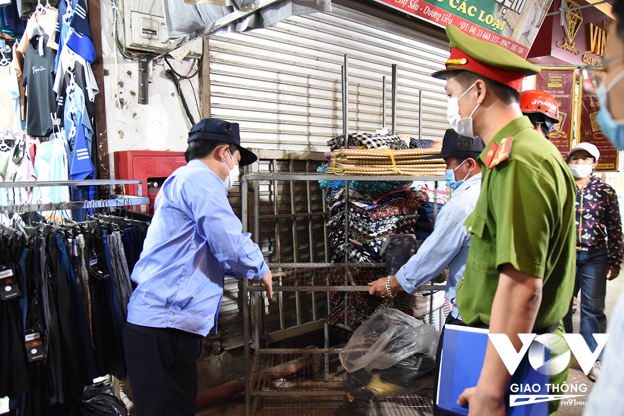 Cảnh sát PCCC&CNCH yêu cầu một hộ kinh doanh tại chợ Sấu (xã Dương Liễu) di chuyển một số hàng hóa che khuất tủ đựng thiết bị PCCC.