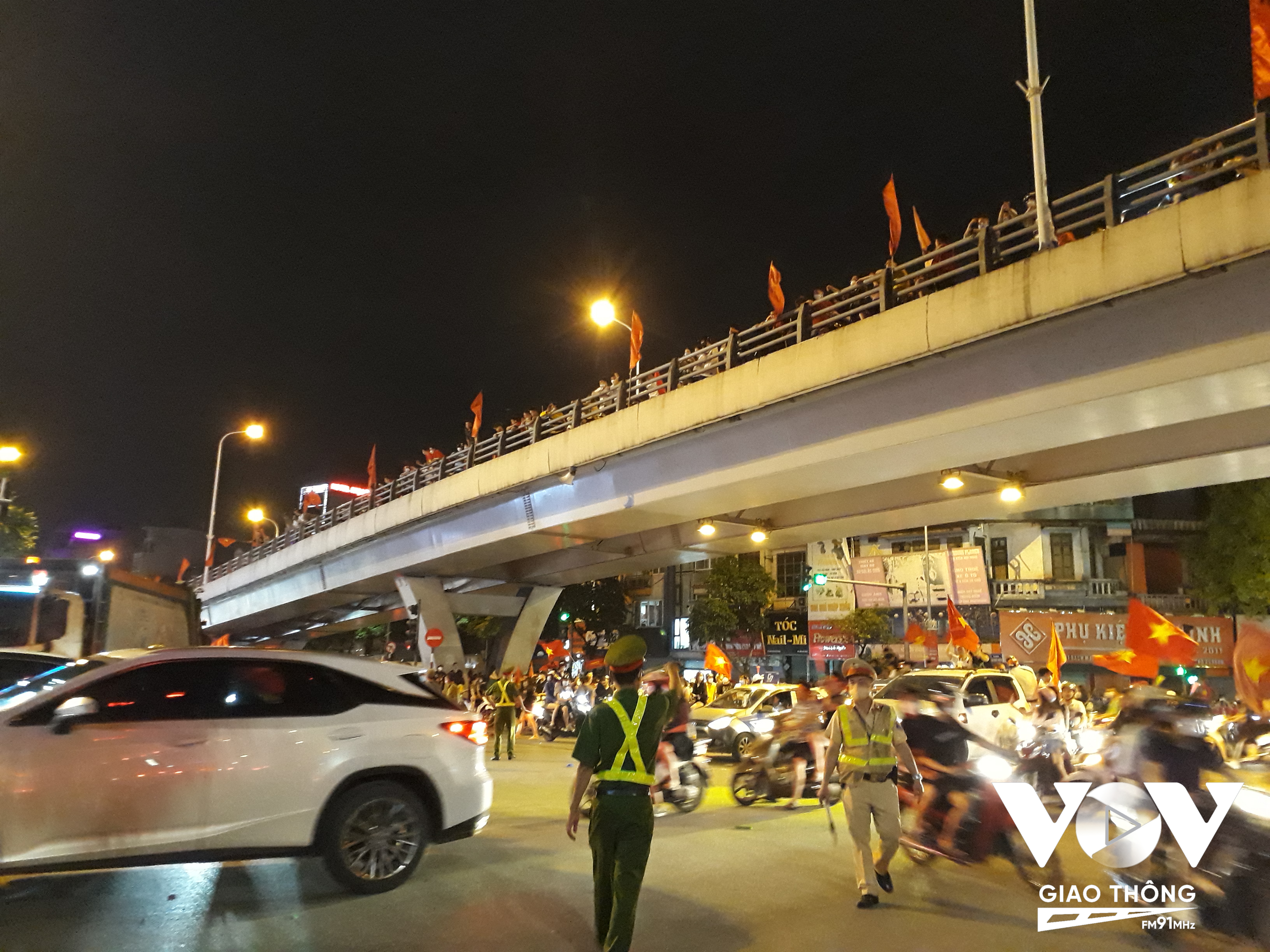Ngã 4 Phố Huế - Đại Cồ Việt, cả trên lẫn dưới cầu rất đông cổ động viên reo hò, phất cờ (Ảnh: Chấn Hải/VOVGT)