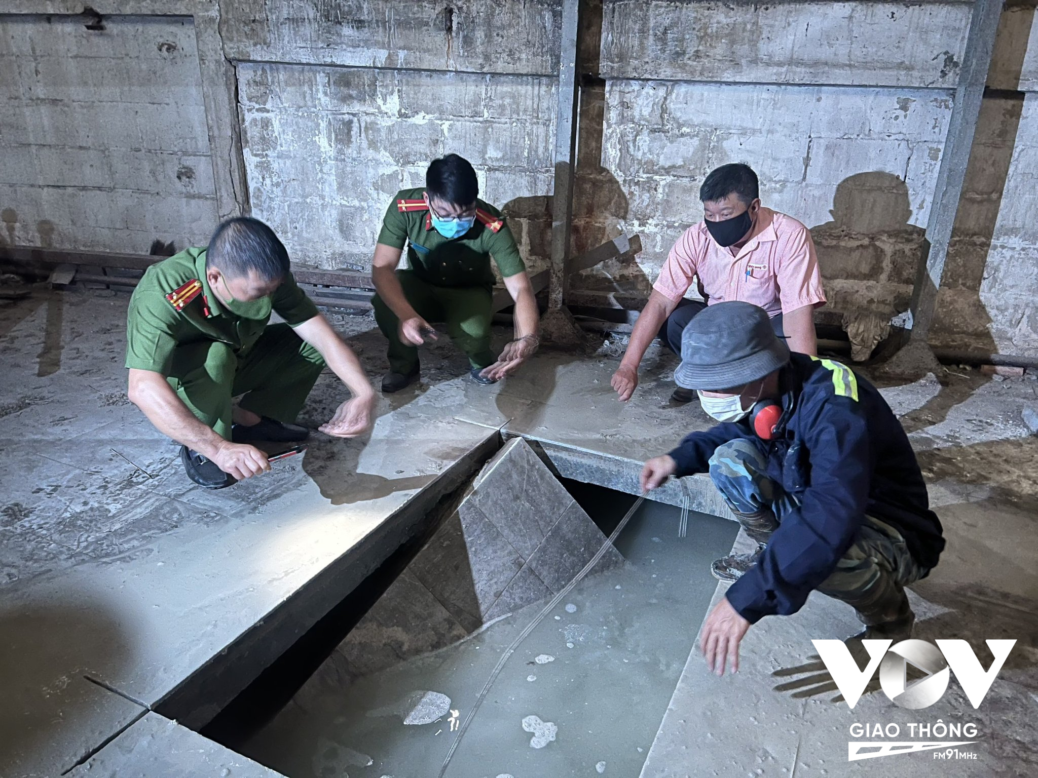 Lực lượng chức năng cho tiến hành cắt nền bê tông để để khai quật hệ thống hầm chôn chất thải bên trong Xí nghiệp Đèn ống - Công ty CP Bóng đèn Điện Quang.