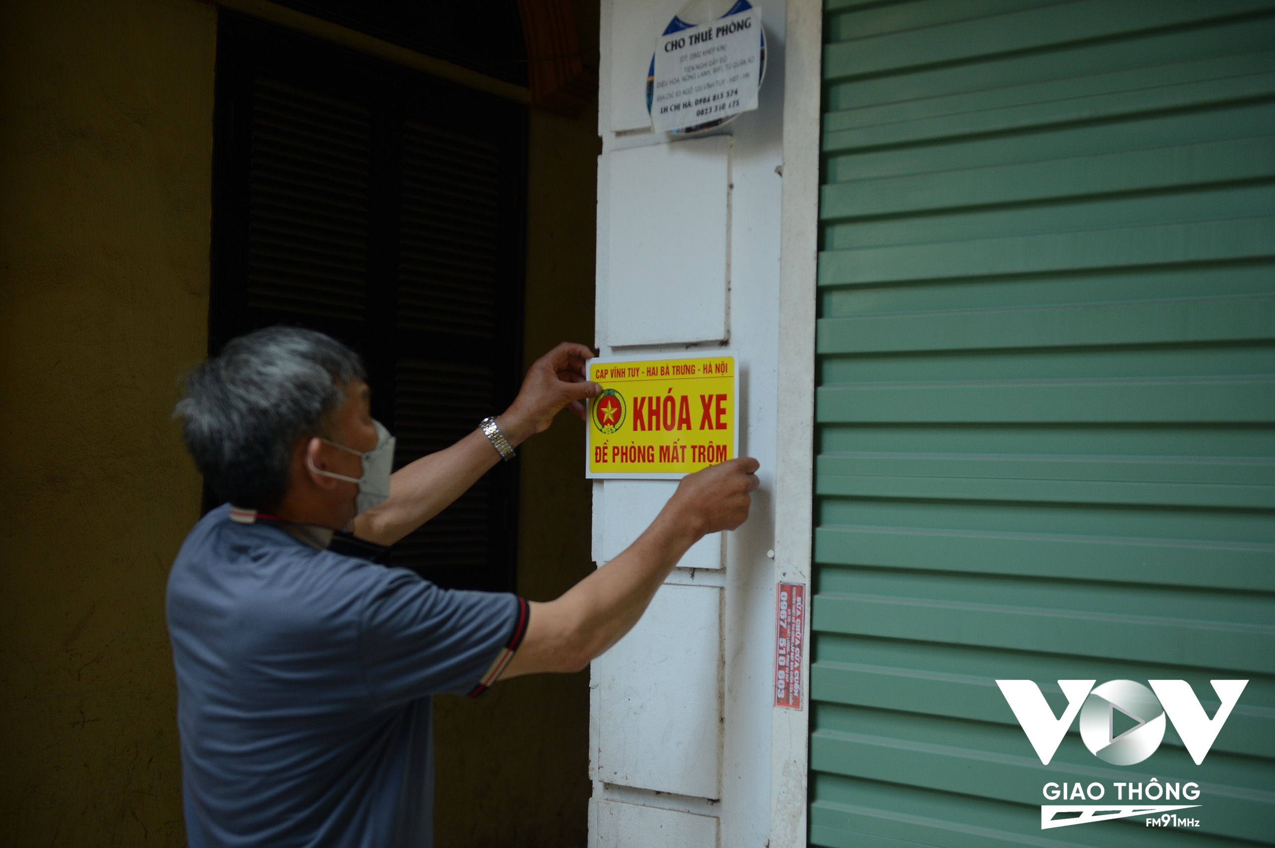 Bác Hoàng Ngọc Long, tổ trưởng tổ bảo vệ dân phố khu dân cư 25, phường Vĩnh Tuy đang dán các biển báo đề phòng trộm, cắp
