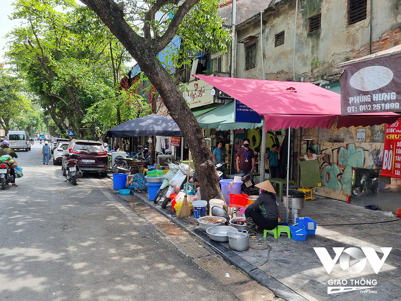Hàng ăn trên đường Phùng Hưng vô tư rửa bát ngay tại điểm dừng xe buýt, căng bạt che khuất biển chỉ dẫn lộ trình