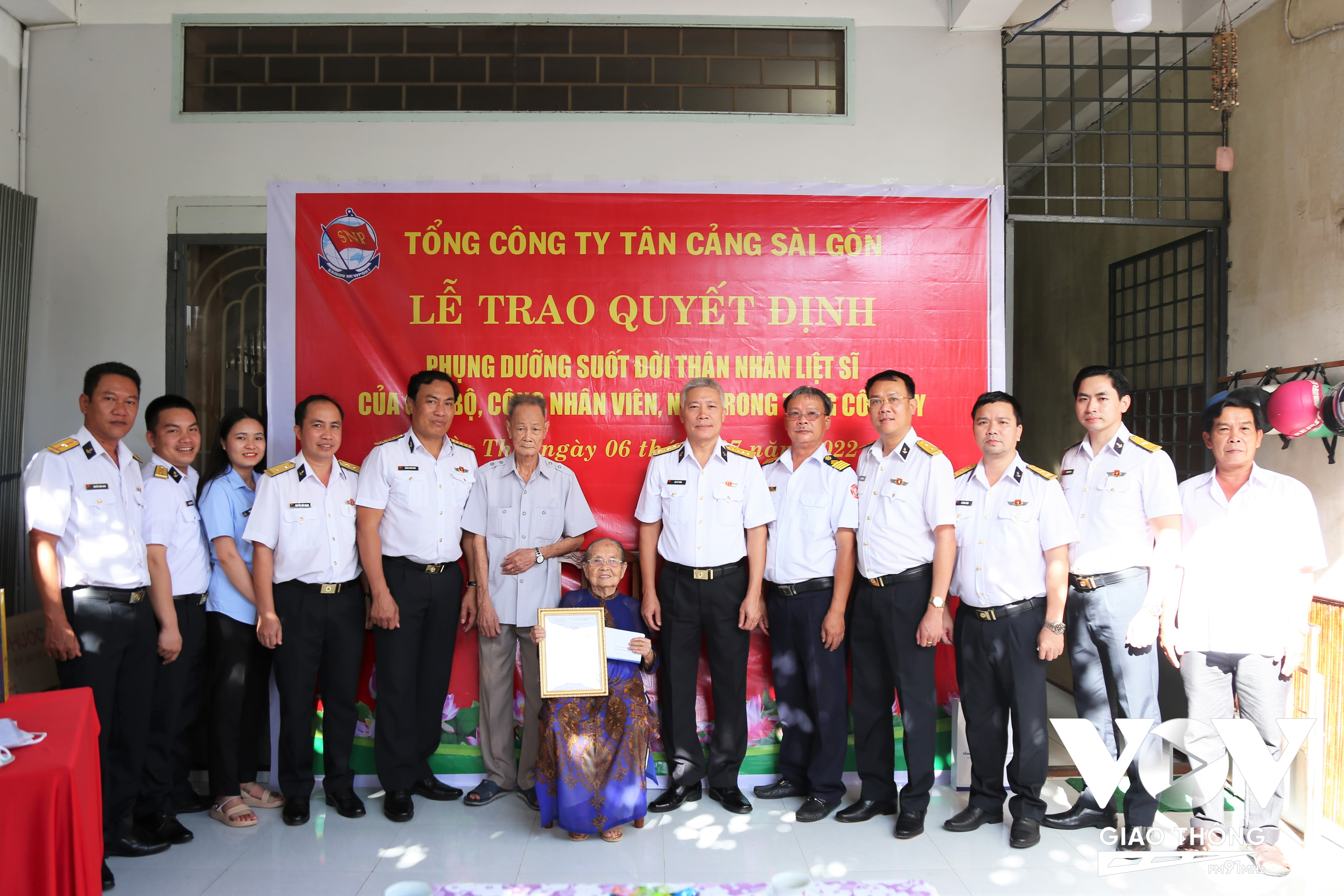Đại tá Bùi Sĩ Tuấn (người thứ 6 bên phải), Phó Tổng giám đốc TCT Tân Cảng Sài Gòn trao Quyết định phụng dưỡng bà Nguyễn Thị Thơi.