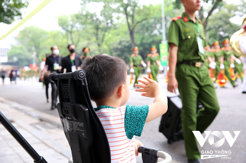 Một em nhỏ thích thú vẫy tay chào các chiến sĩ cảnh sát.