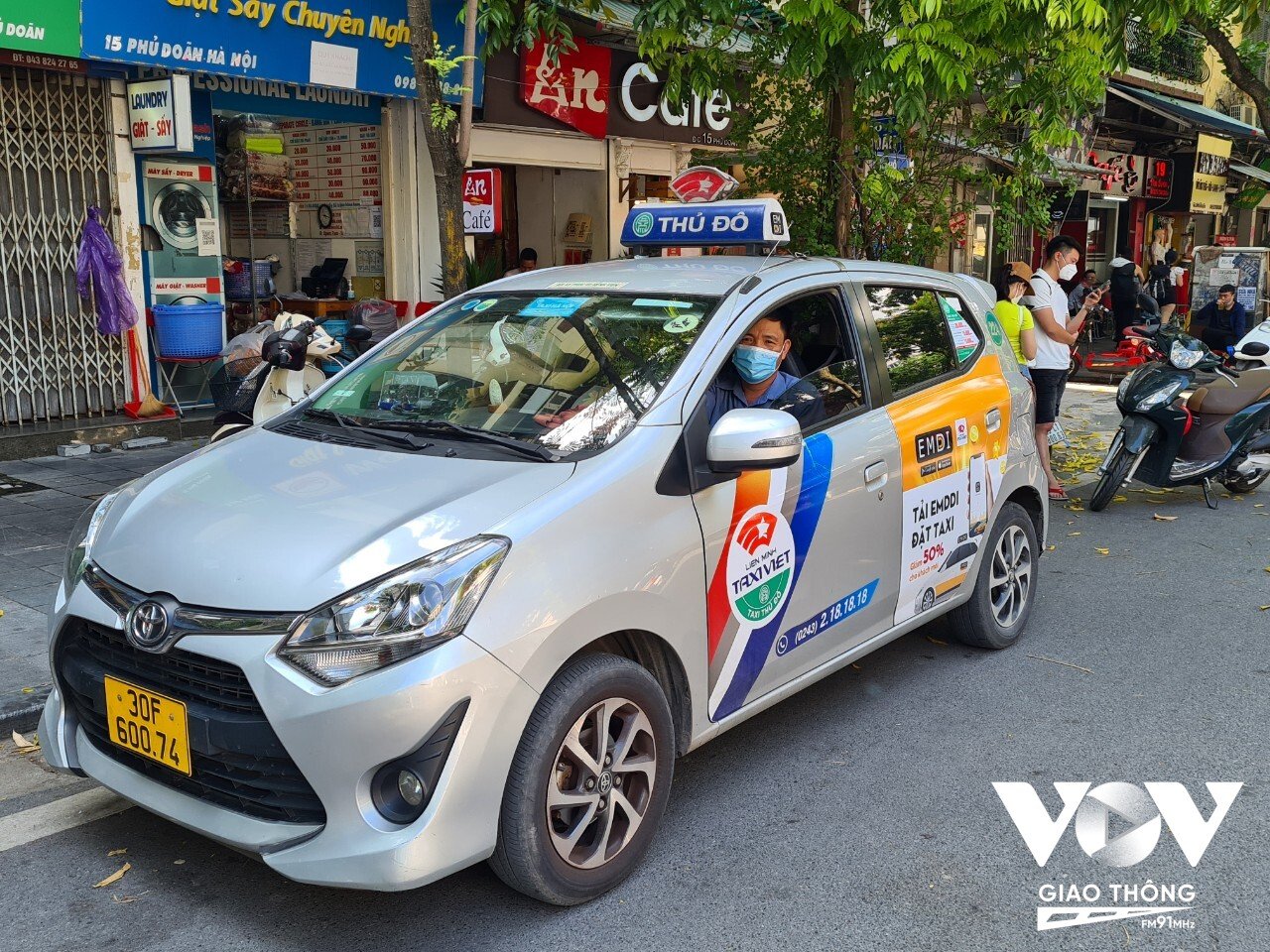 Tài xế taxi Nguyễn Xuân Hiển không dám nổ máy, bật điều hòa đợi khách dù trời nắng nóng.