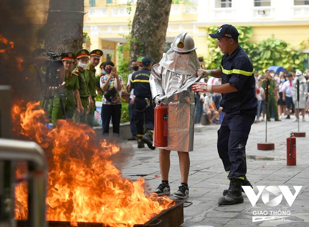 Các em học sinh được trải nghiệm bộ quần áo chống lửa chuyên dụng của cảnh sát PCCC.