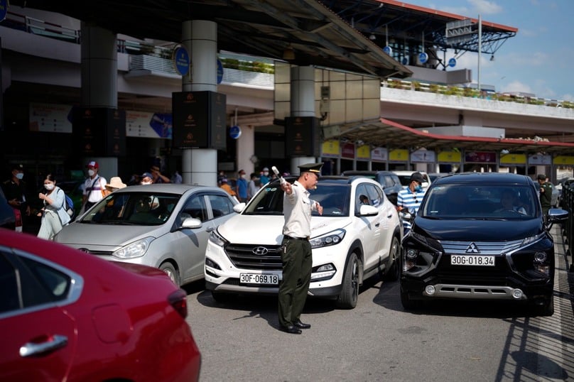 Phía trước nhà ga, nhân viên An ninh kiểm soát sân đỗ ô tô giữa các làn phương tiện vây kín