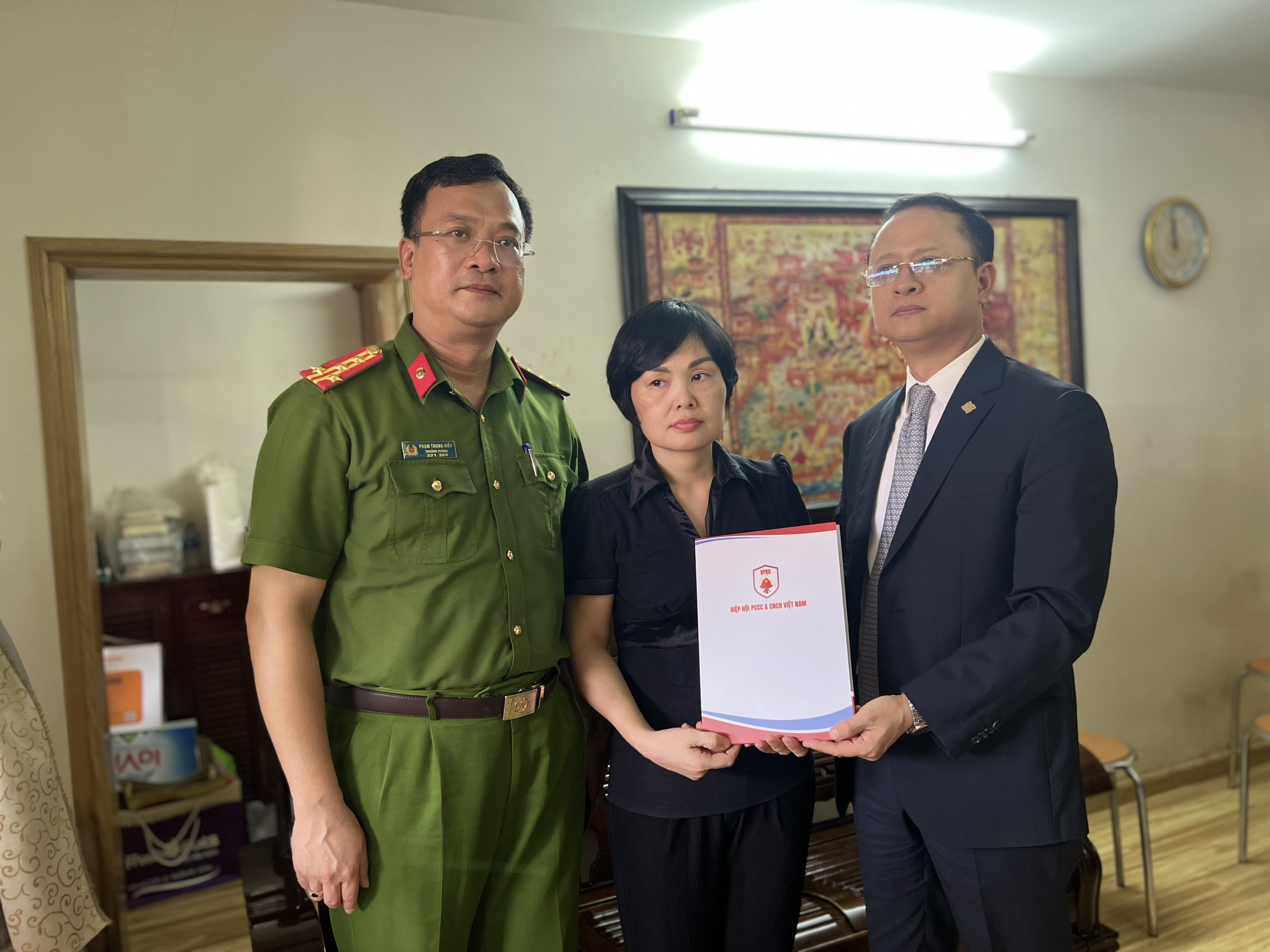 Đại diện Phòng Cảnh sát PCCC&CNCH và Hiệp hội PCCC và CNCH Việt Nam trao tặng sổ tiết kiệm cho gia đình Liệt sỹ Nguyễn Đình Phúc.
