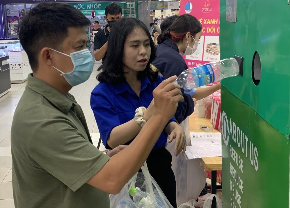Đặng Nhật Uyên (sinh viên năm 4, Trường Đại học Nha Trang) hướng dẫn người dân sử dụng máy thu gom rác trong chương trình “Hè xanh mát, tích rác nhận quà” Ảnh: Thục Hiền/Tiền Phong