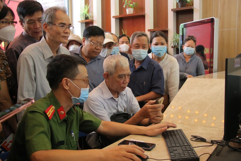 Cán bộ công an hướng dẫn người dân sử dụng dịch vụ công trực tuyến tại quận Bình Thạnh.