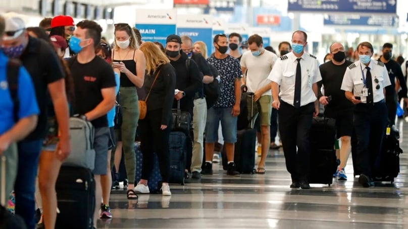 Hai phi công đi ngang qua một hàng dài hành khách chờ làm thủ tục an ninh tại Sân bay Quốc tế O'Hare, Chicago, Mỹ - Ảnh AP