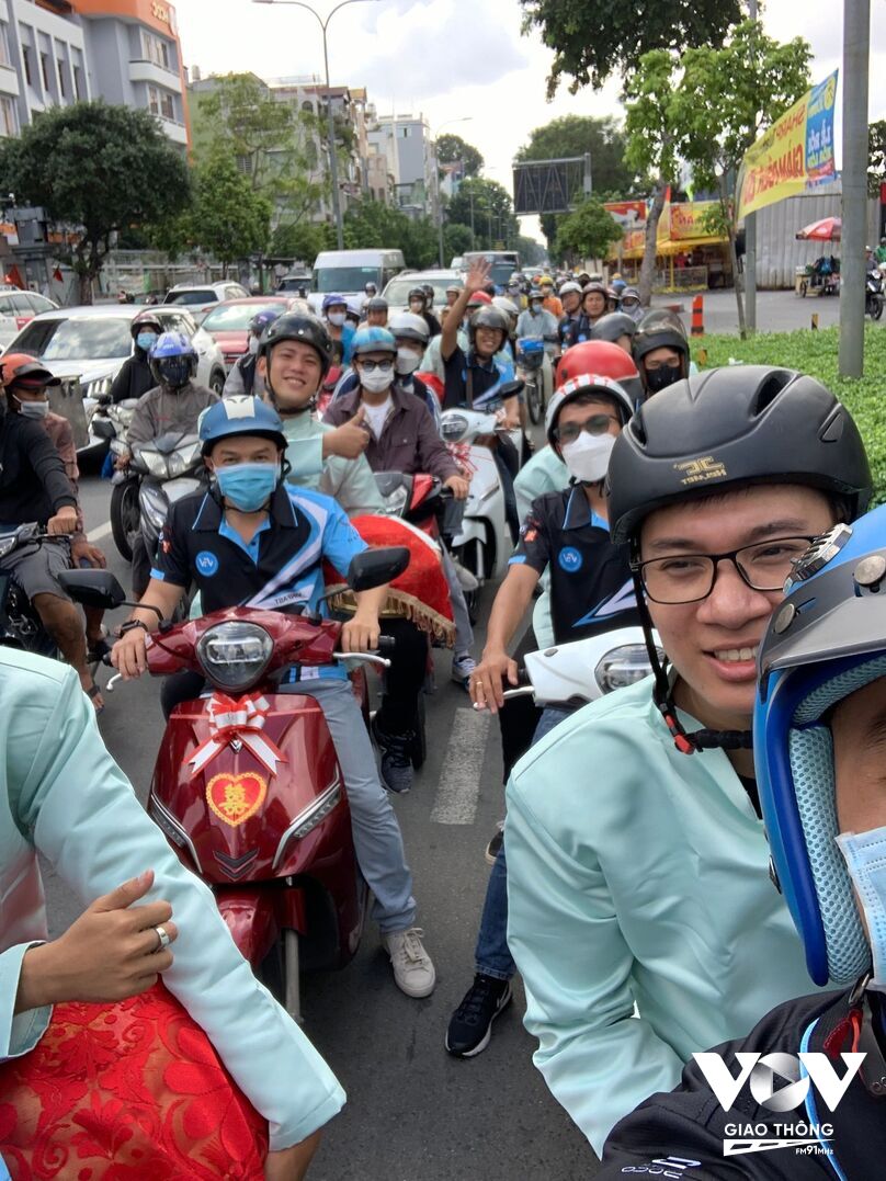 Đoàn đón dâu bằng xe máy điện nhận được sự quan tâm không nhỏ của người tham gia giao thông trên đường phố TPHCM sáng nay