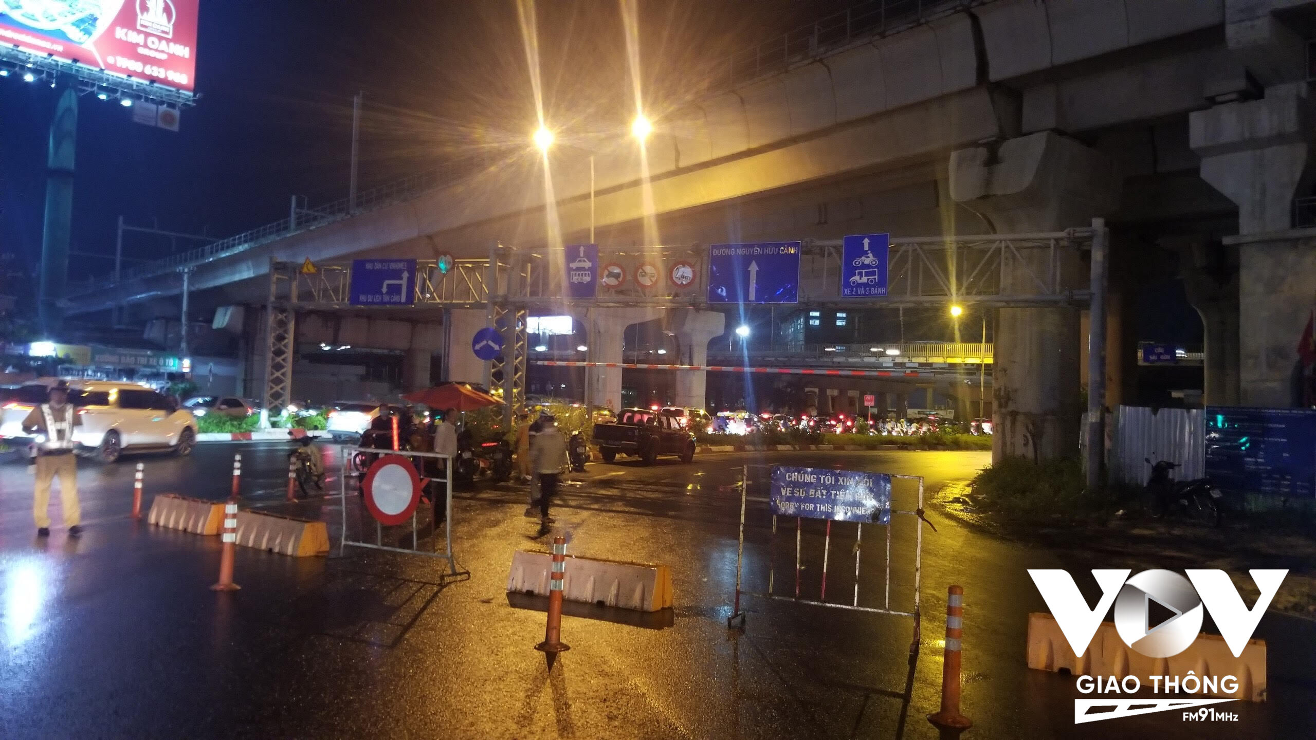 Lực lượng chức năng tiến hành đặt rào chặn, phong tỏa lối đi chuyển chuyển lên cầu vượt Nguyễn Hữu Cảnh tối 29/9. Ảnh: Nhất Hoàng