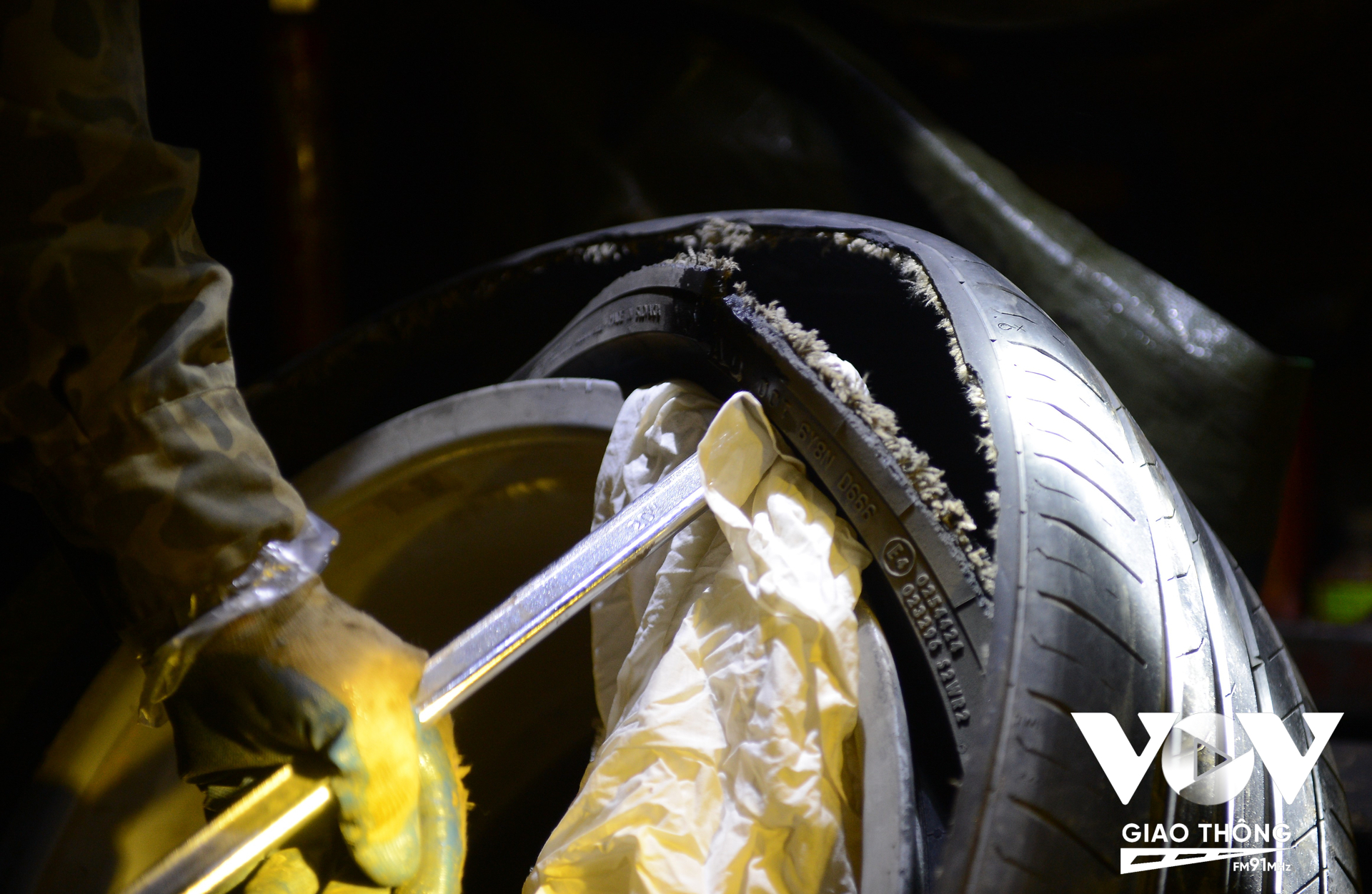 Anh Độ cẩn thận lót khăn lên vành xe ô tô trước khi tì dụng cụ vào để bẩy lốp hỏng ra ngoài, việc này hạn chế vành xe bị tác động xước sát trong quá trình làm.