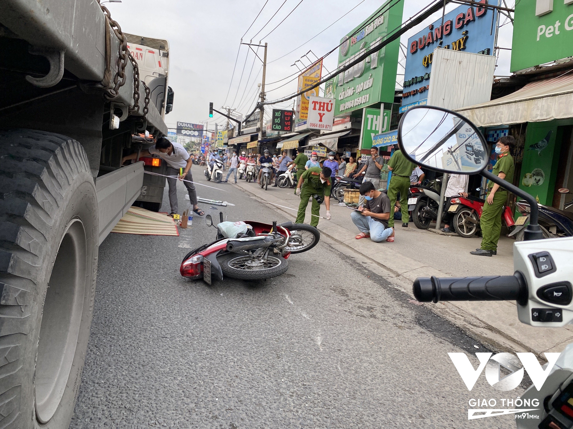 Sau va chạm với 1 xe máy chạy cùng chiều, người phụ nữ ngã xuống đường và bị xe đầu kéo cán tử vong.
