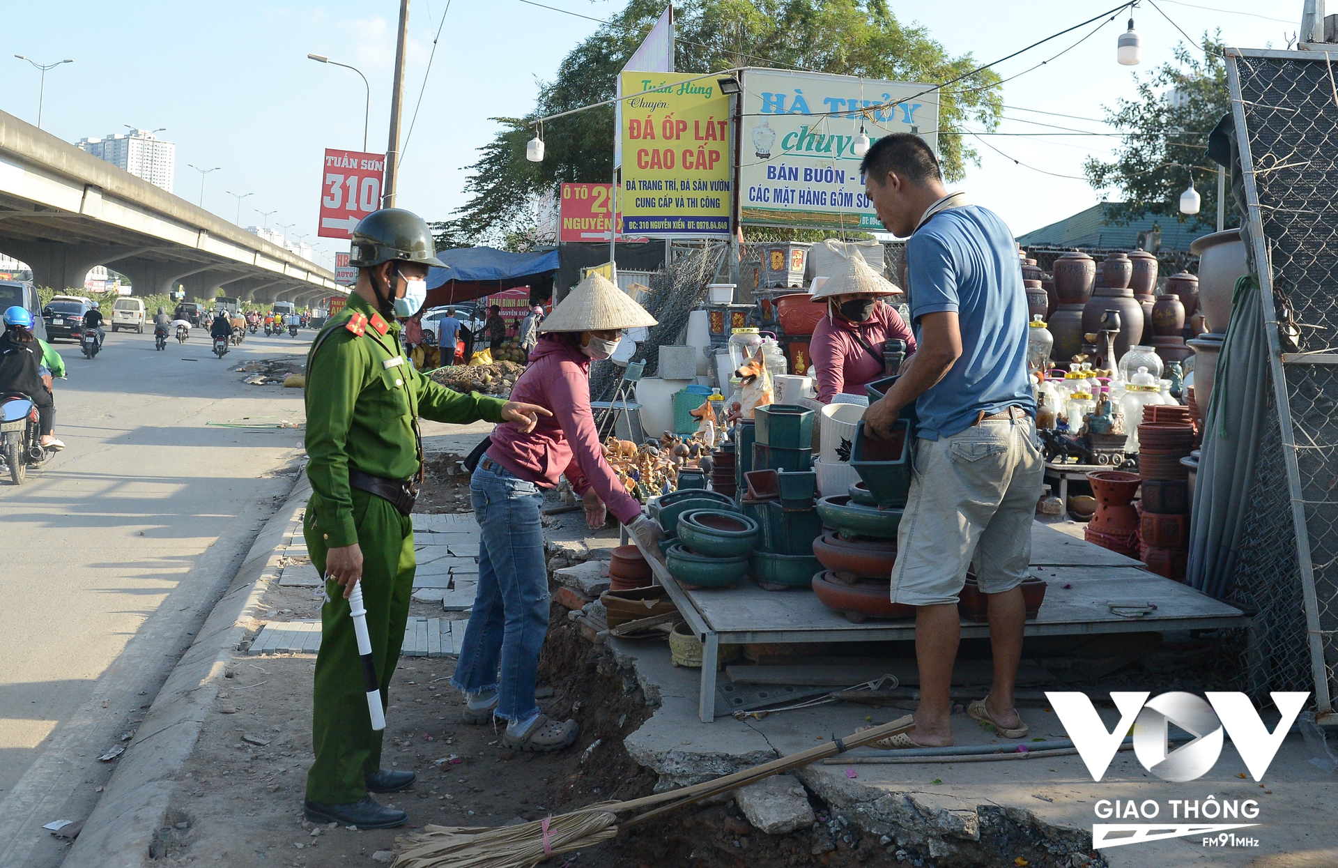 Lực lượng chức năng phường Đại Kim (quận Hoàng Mai) nhắc nhở người bán hàng tại đây thu dọn hàng hóa, trả lại hiện trạng đất.