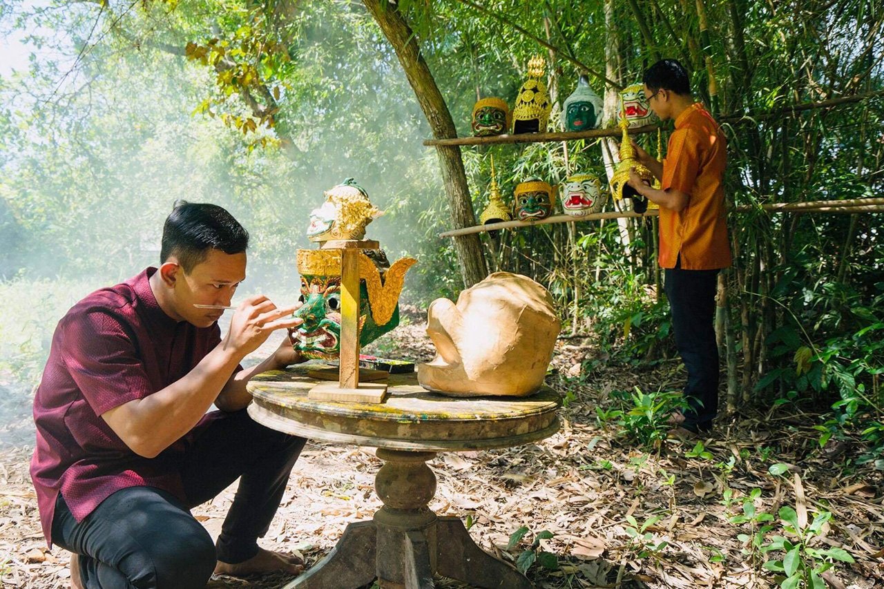 Thầy Thắng (ngồi) cùng học trò tạo những sản phẩm mão, mặt nạ biểu diễn truyền thống Khmer - Ảnh Báo Thanh Niên