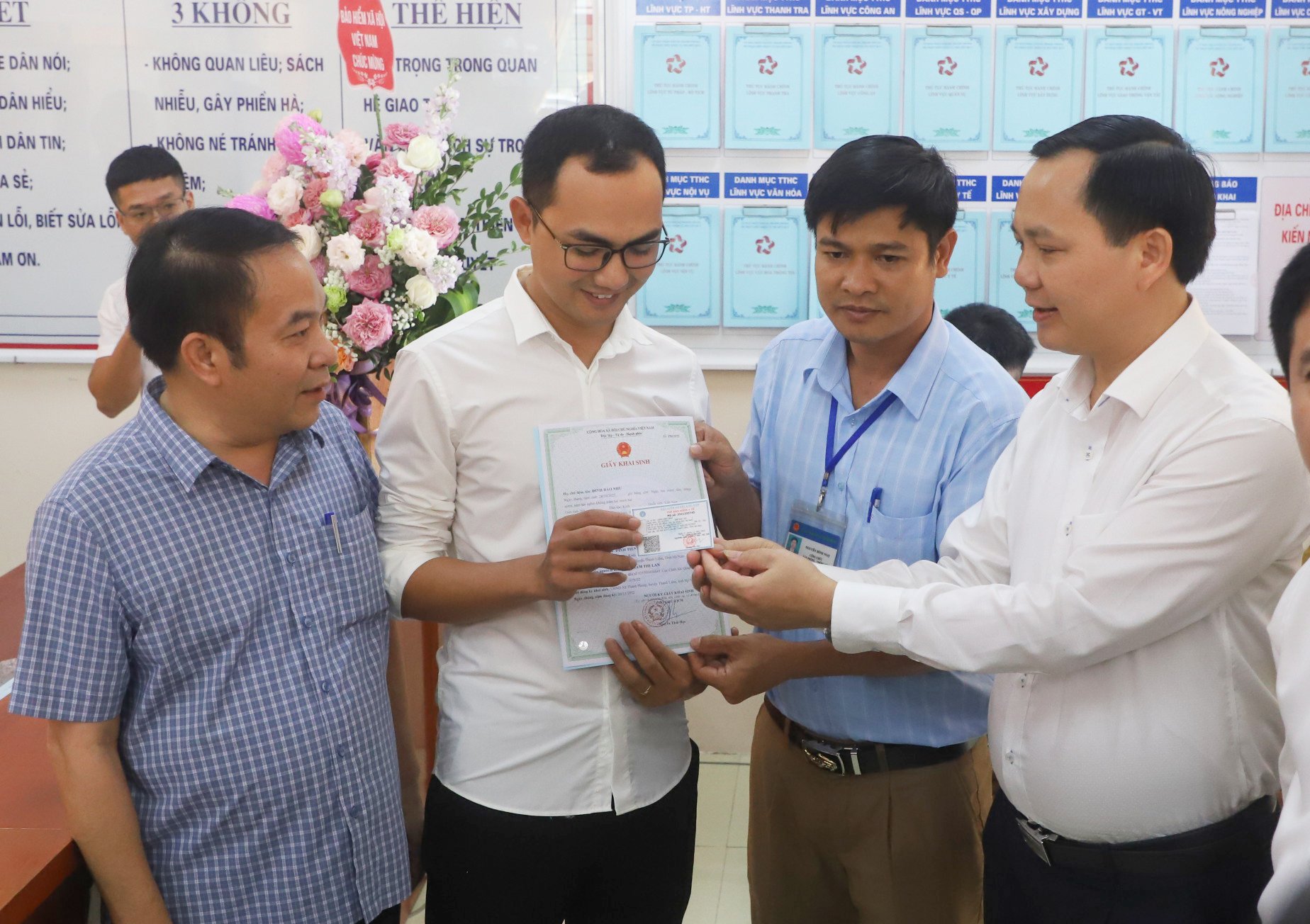 Phó Tổng giám đốc BHXH Việt Nam Chu Mạnh Sinh trao thẻ BHYT của bé gái cho anh Đinh Tiến Hoàng.