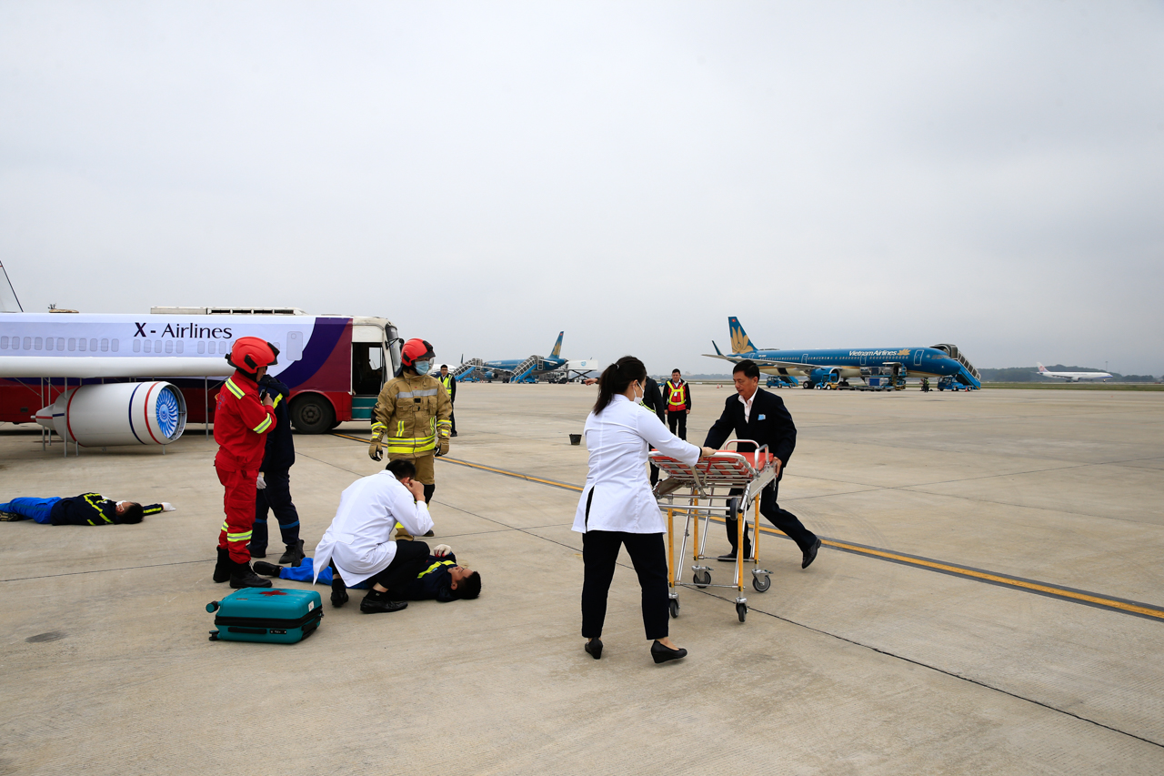 Các y bác sĩ thuộc Đội y tế khẩn nguy - Trung tâm Điều hành sân bay Nội Bài thực hiện sơ cứu người bị nạn tại hiện trường