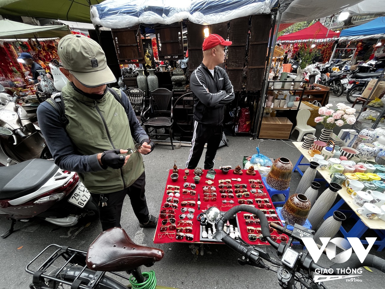 Một khách chơi chợ đang ngắm nghía chiếc gọng kính cổ
