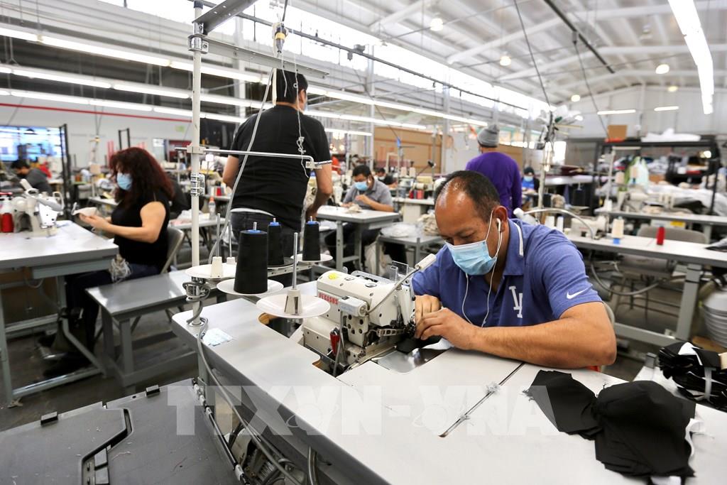 Công nhân làm việc tại nhà máy ở thành phố Vernon, Los Angeles, California, Mỹ ngày 16/4/2020. Ảnh: THX/ TTXVN