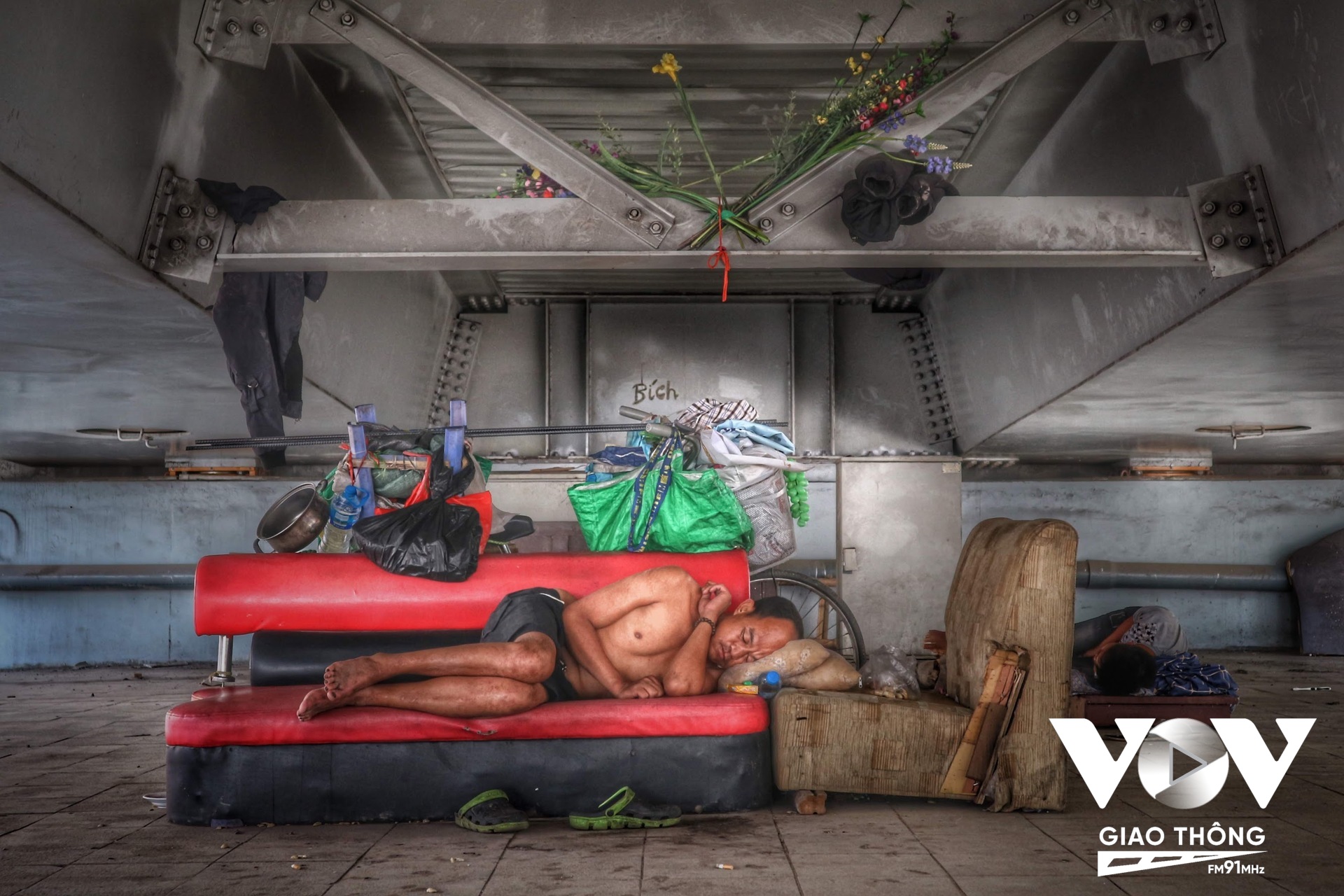 Giấc ngủ ngon lành dưới gầm cầu của một người vô gia cư. Chiếc xe đạp dựng bên cạnh cũng không lo bị mất, như các phương tiện đắt tiền khác...
