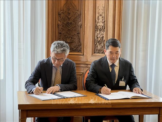 Thứ trưởng Bộ Tài chính Cao Anh Tuấn và Phó Tổng Thư ký OECD Yoshiki Takeuchi ký hiệp định - Ảnh TTXVN