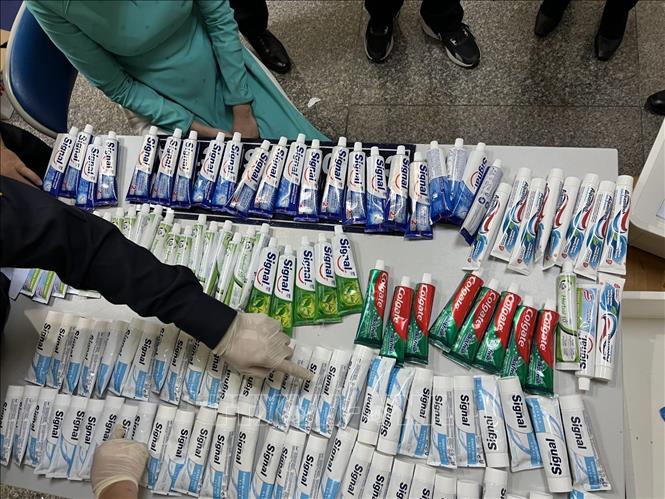 Kiểm đếm lô hàng chất ma túy được giấu trong những tuýp kem đánh răng bị thu giữ từ hành lý của 4 tiếp viên hàng không. Ảnh: TTXVN phát