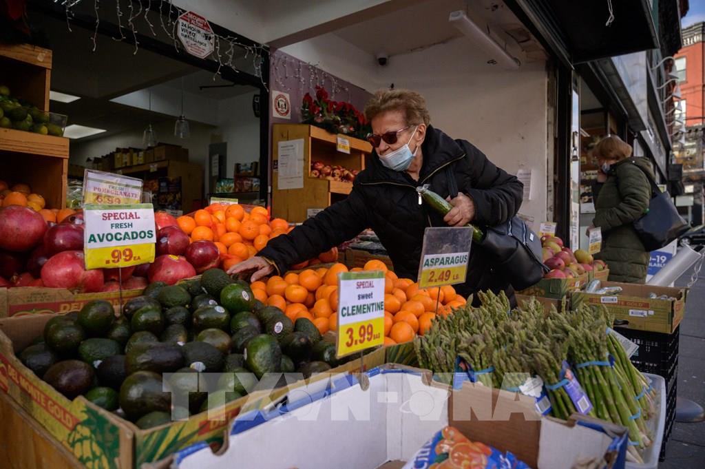 Khách hàng chọn mua hàng tại một quầy bán hoa quả ở New York, Mỹ. Ảnh: AFP/TTXVN