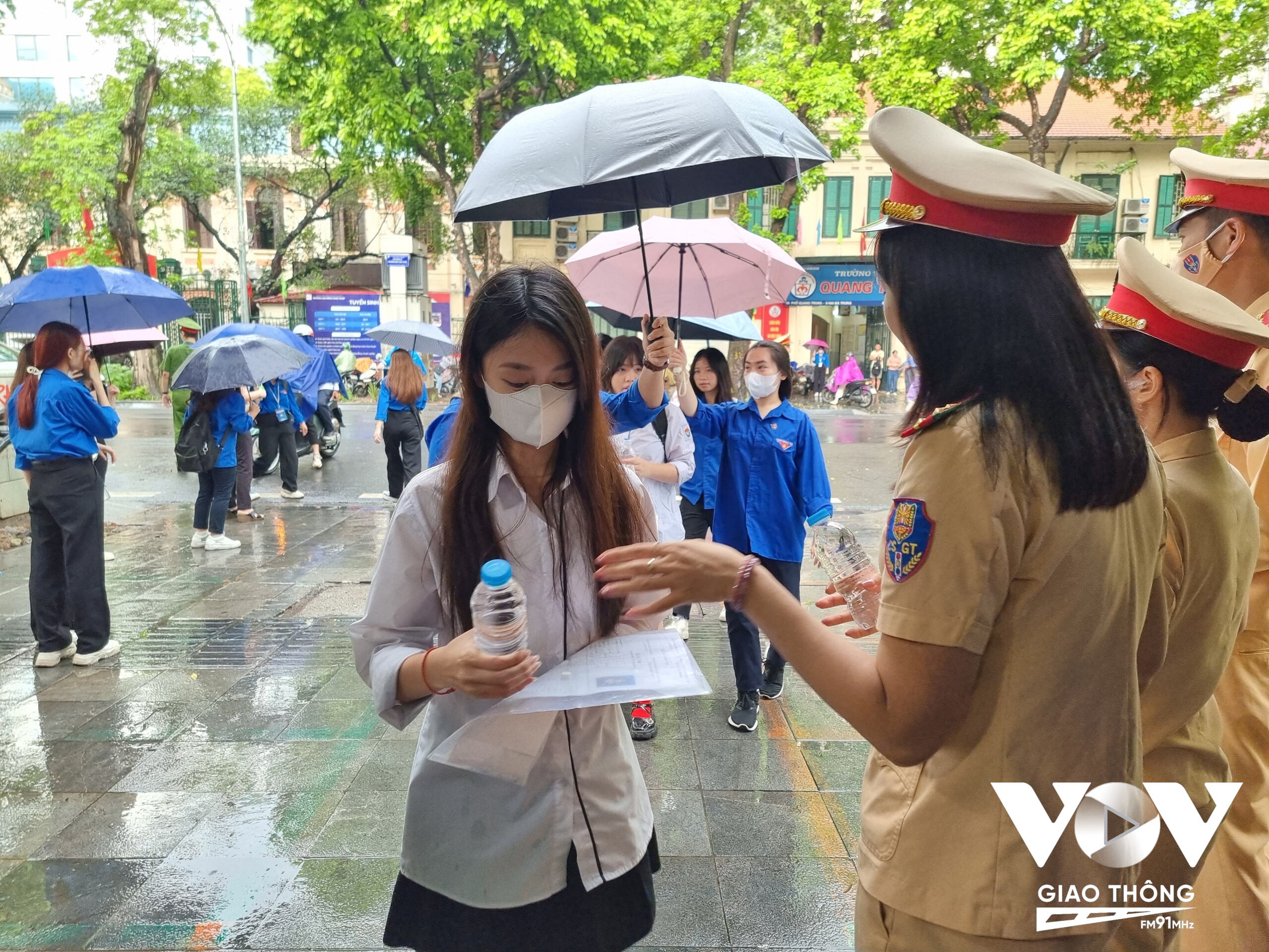 Lực lượng CSGT phát nước uống cho các thí sinh tại điểm trường THPT Trần Phú.