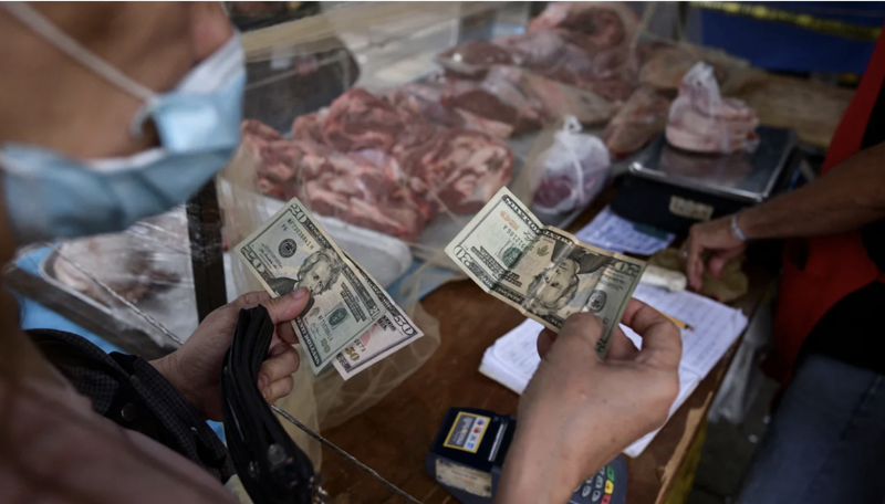 Người dân mua thực phẩm bằng USD tại một khu chợ ở Caracas, Venezuela - Ảnh: Reuters.