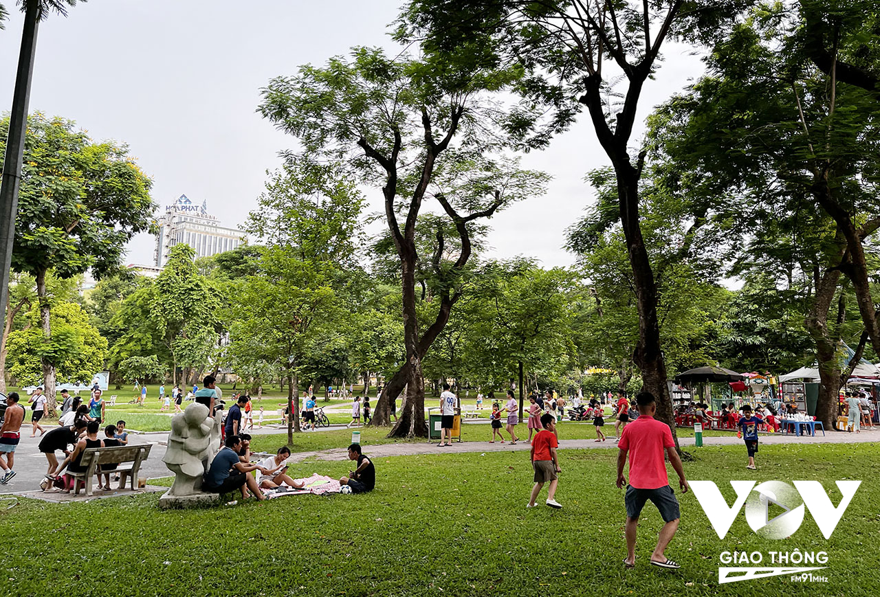 Người lớn, trẻ nhỏ thoải mái vui chơi trong khuôn viên công viên, ngay cạnh phố đi bộ