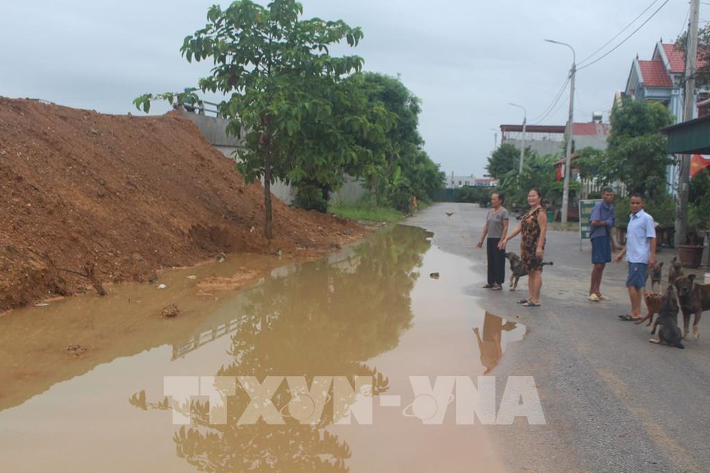 Người dân Khu tái định cư làng Kim Bôi (xã Đông Thanh) rất bức xúc vì cống Tây bị lấp trong quá trình thi công cầu vượt Cao tốc - Quốc lộ 45 gây ngập đường và nhà dân. Ảnh: TTXVN