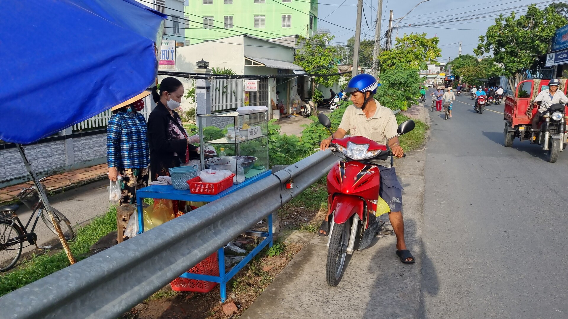 Trong khi nhà lồng chợ 'vắng tanh' thì các hộ kinh doanh lại tập trung sát đường giao thông mua bán. Hình ảnh này, nếu xe dừng đỗ mua hàng gây mất an toàn giao thông