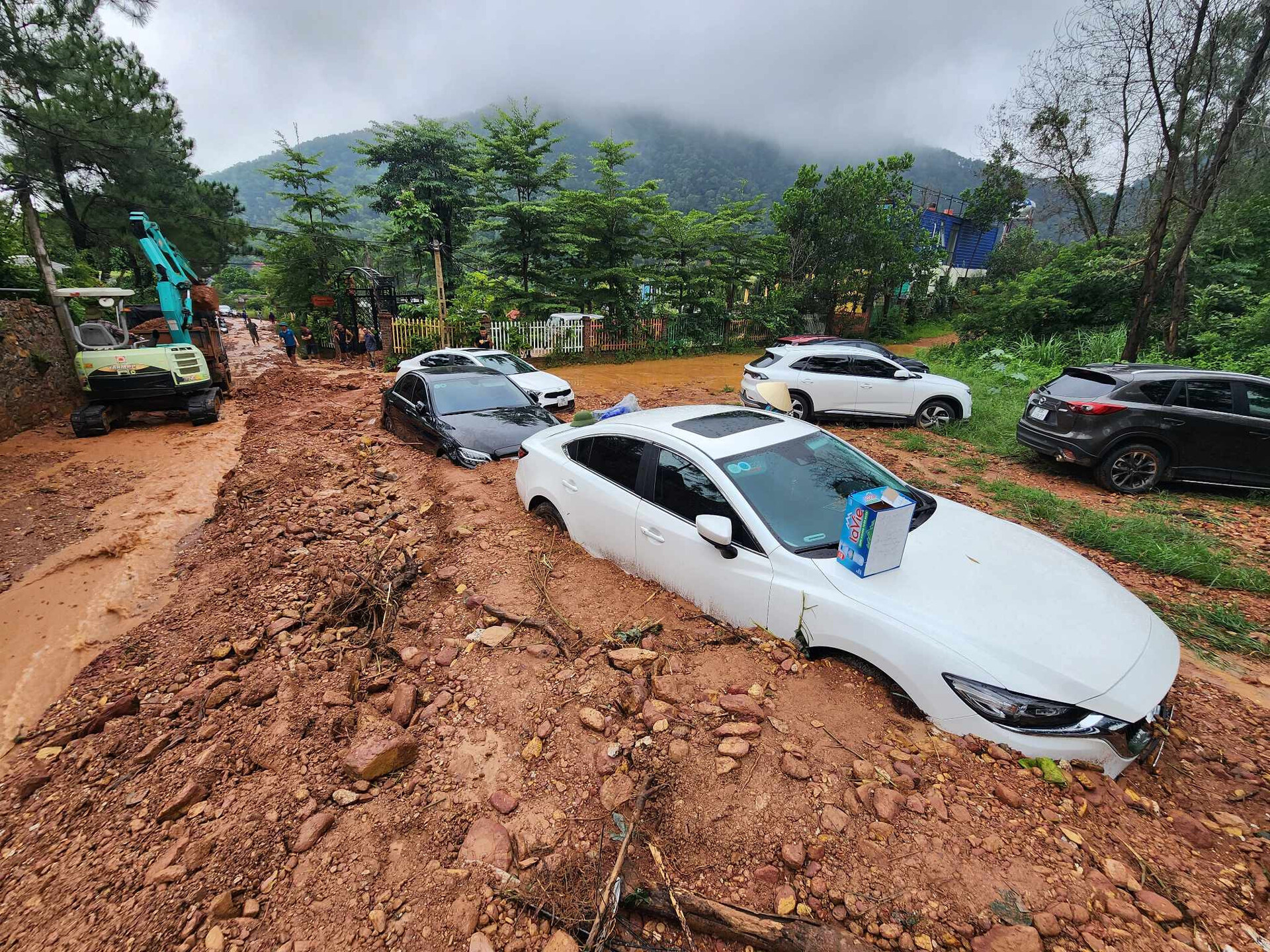 Cơn mưa lớn sáng 4/8 gây sạt lở đất, đá xuống tuyến đường ở xã Minh Phú (huyện Sóc Sơn, Hà Nội) khiến hàng loạt ô tô bị vùi lấp. Ảnh: Vietnamnet