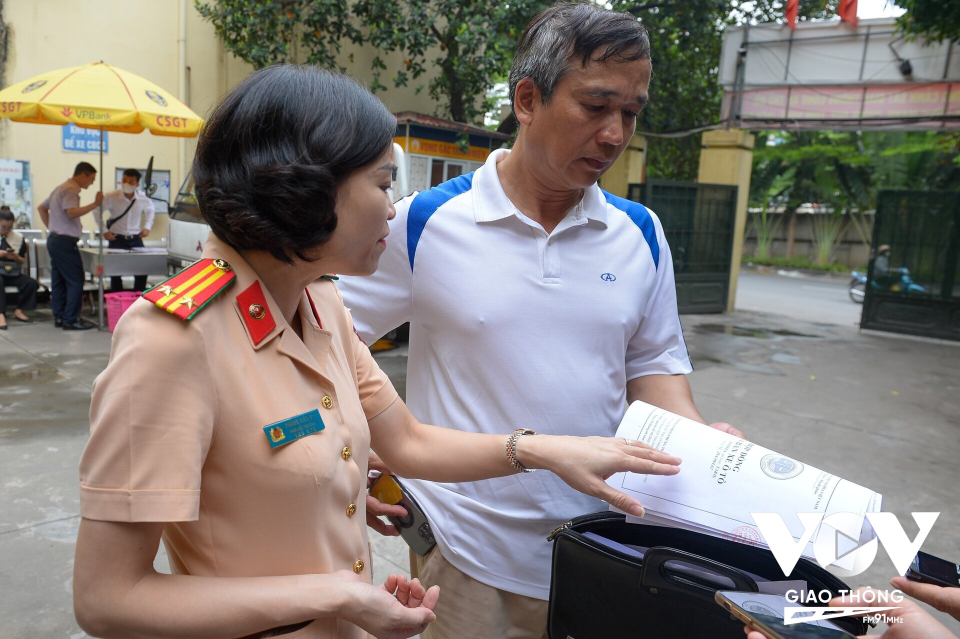 Ông Phạm Quang Đản (ở Nghĩa tân, Cầu Giấy) đang được cán bộ Đội đăng ký xe hướng dẫn thủ tục sang tên đổi chủ