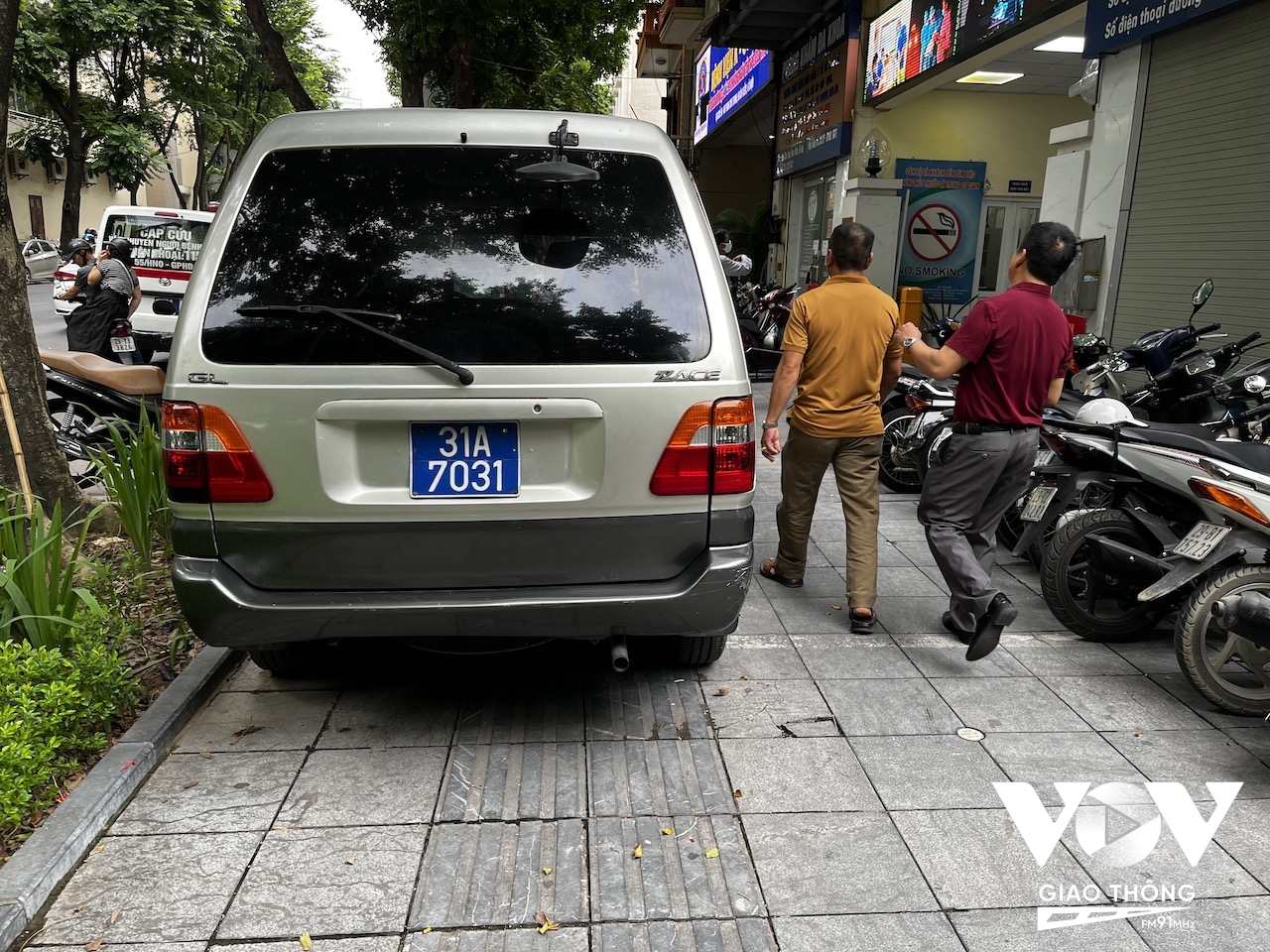 Một chiếc xe công đỗ ngay trên vỉa hè, vừa lấn chiếm vỉa hè, vừa chiếm luôn cả làn đường cho người khiếm thị... trên phố Phan Chu Trinh