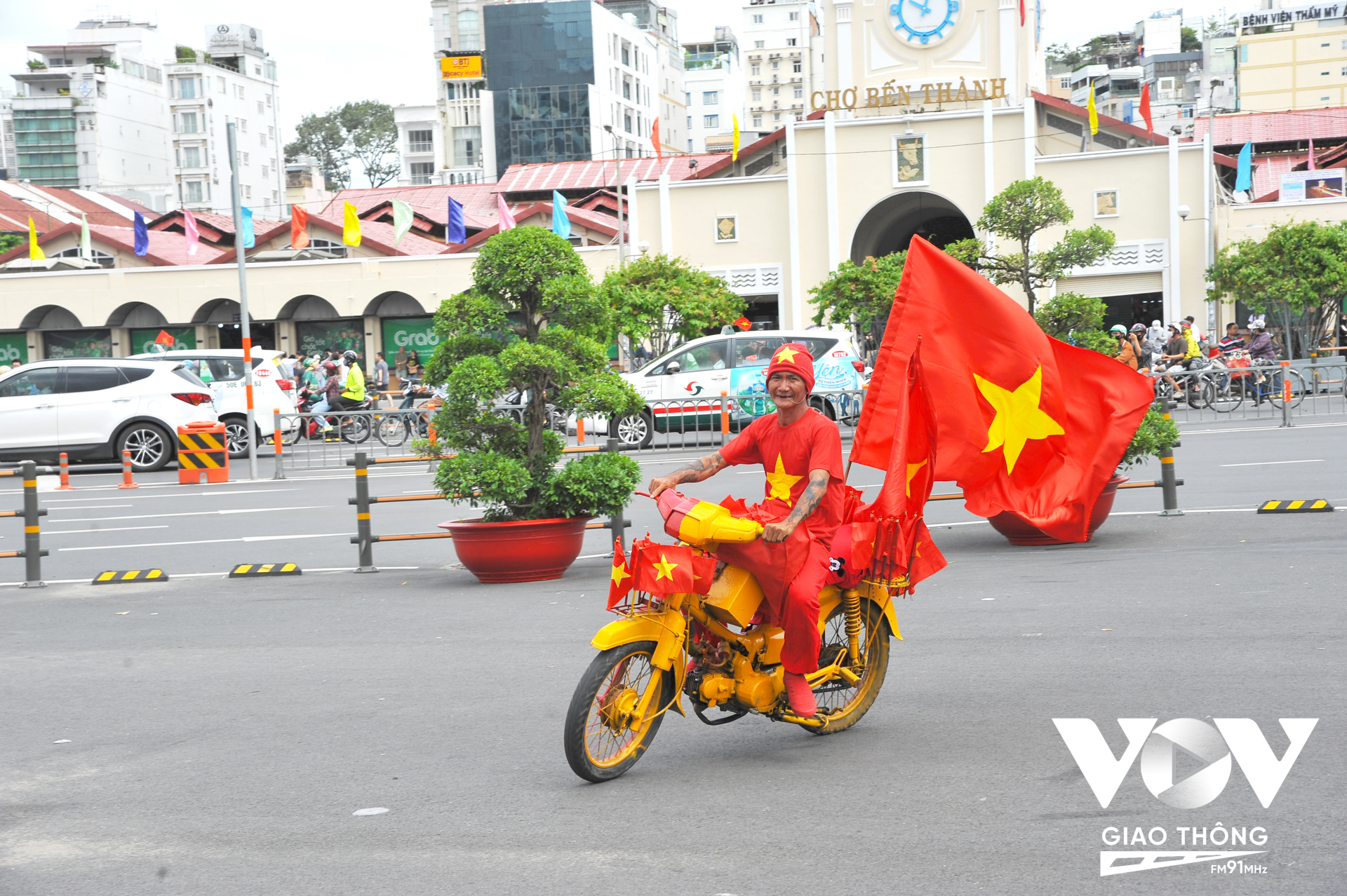 Chiếc xe máy được sơn với 2 màu chủ đạo đỏ vàng được trang trí bởi các lá cờ Tổ quốc được chú T. (người Việt gốc Hoa) chạy khắp các con đường ở trung tâm TP vào sáng 2/9.
