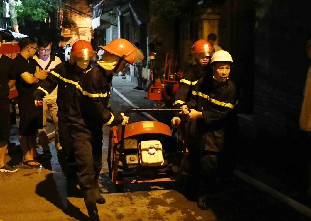 Lực lượng phòng cháy chữa cháy và cứu nạn cứu hộ đưa thiết bị chuyên dụng tiếp cận đám cháy chung cư mini ở Hà Nội - Ảnh: TTXVN