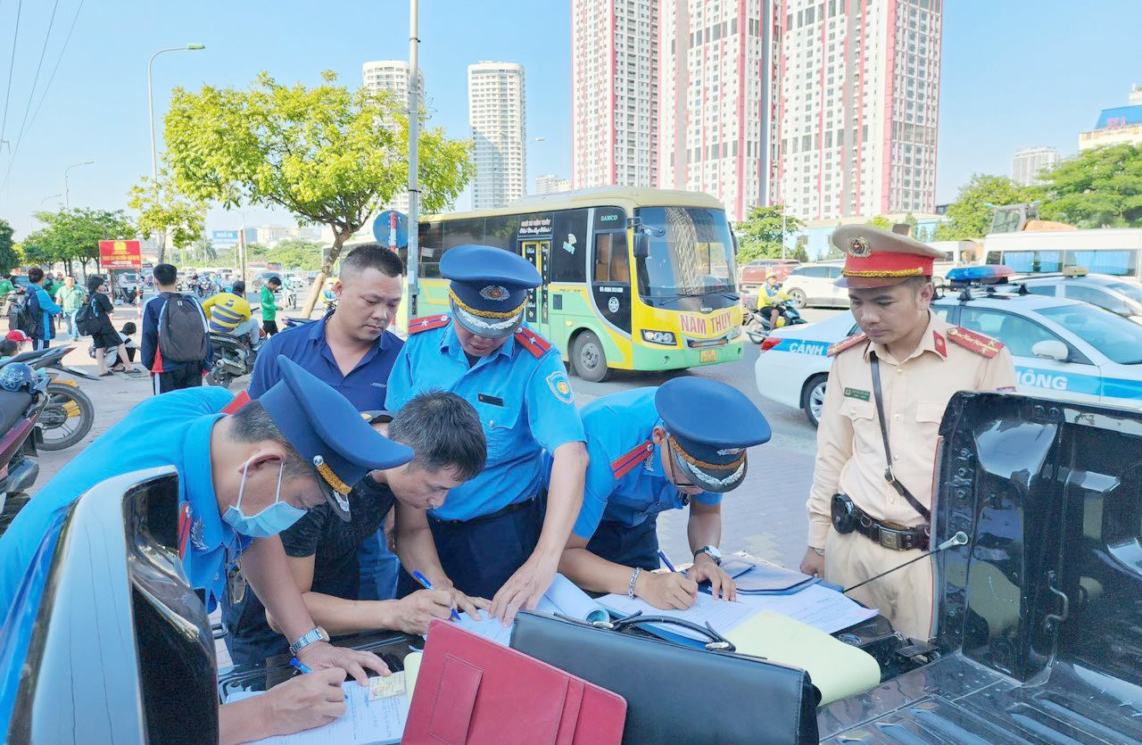 Lực lượng chức năng lập biên bản một xe khách vi phạm tại quận Nam Từ Liêm. Ảnh: Hà Nội mới