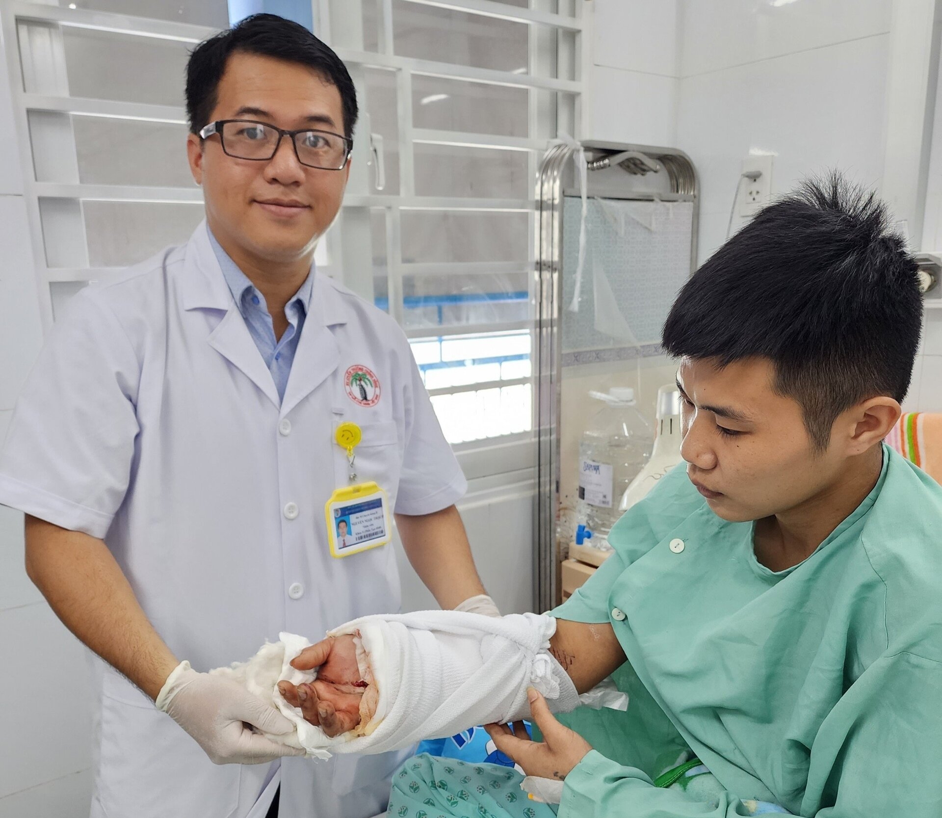 Bác sĩ thăm khám bệnh nhân sau khi mổ nối liền bàn tay cho bệnh nhân