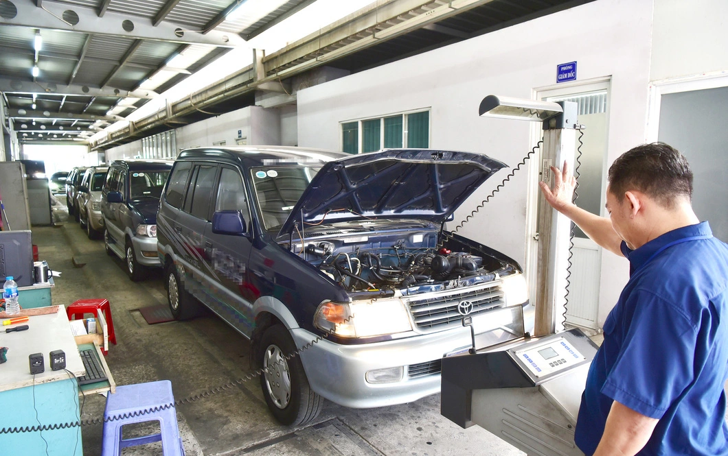 Nhân viên Trung tâm đăng kiểm 50-05V (quận Tân Bình, TP.HCM) kiểm tra thông số an toàn kỹ thuật của xe vào đăng kiểm - Ảnh: Tuổi trẻ.