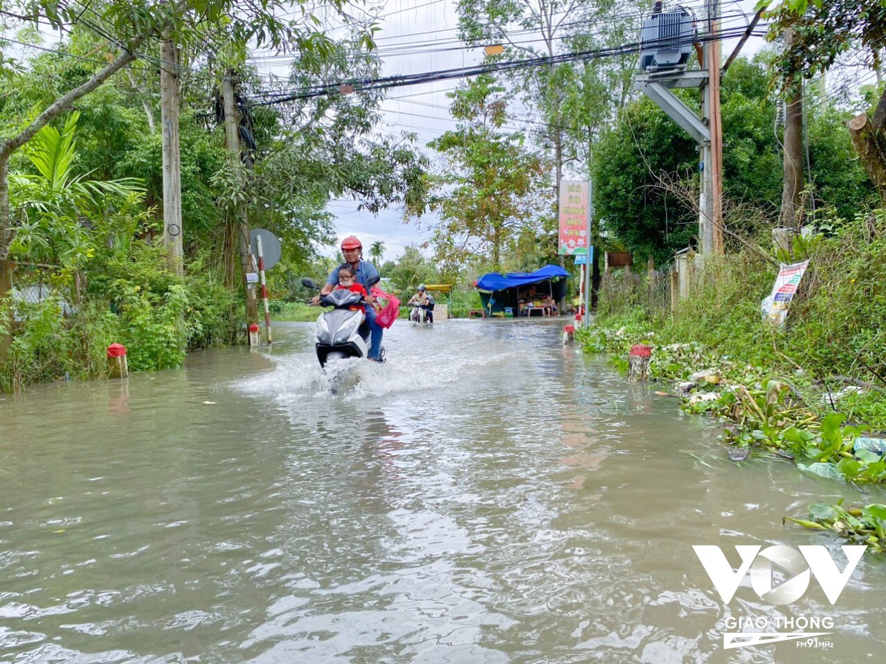 Đường tỉnh 918, đi qua địa phận huyện Phong Điền bị ngập, nhiều phụ huynh chật vật đưa con đến đường.