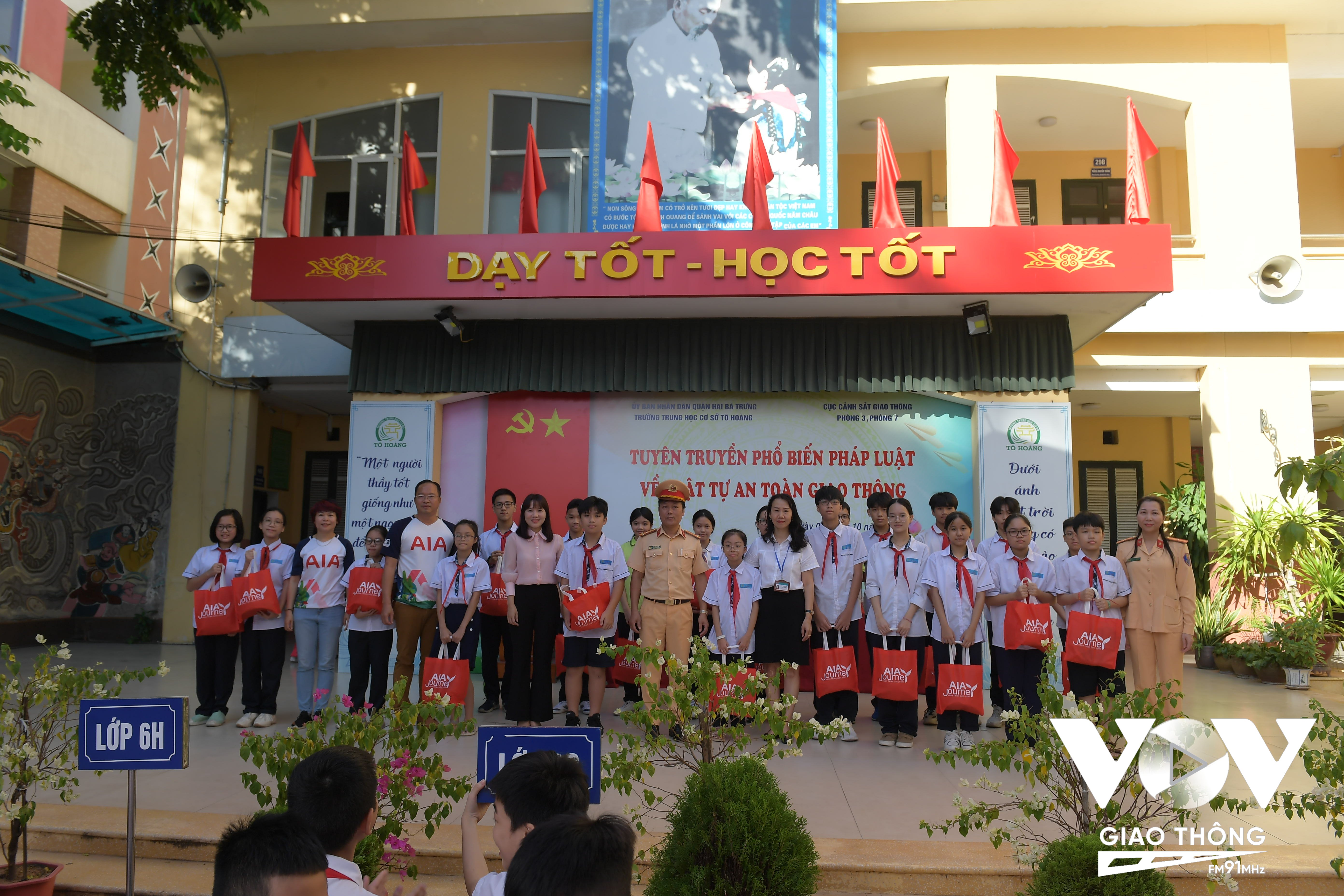 Đại diện Cục CSGT, Quỹ bảo trợ trẻ em Việt Nam, Công ty bảo hiểm nhân thọ AIA Việt Nam tặng quà và mũ bảo hiểm cho các em học sinh.