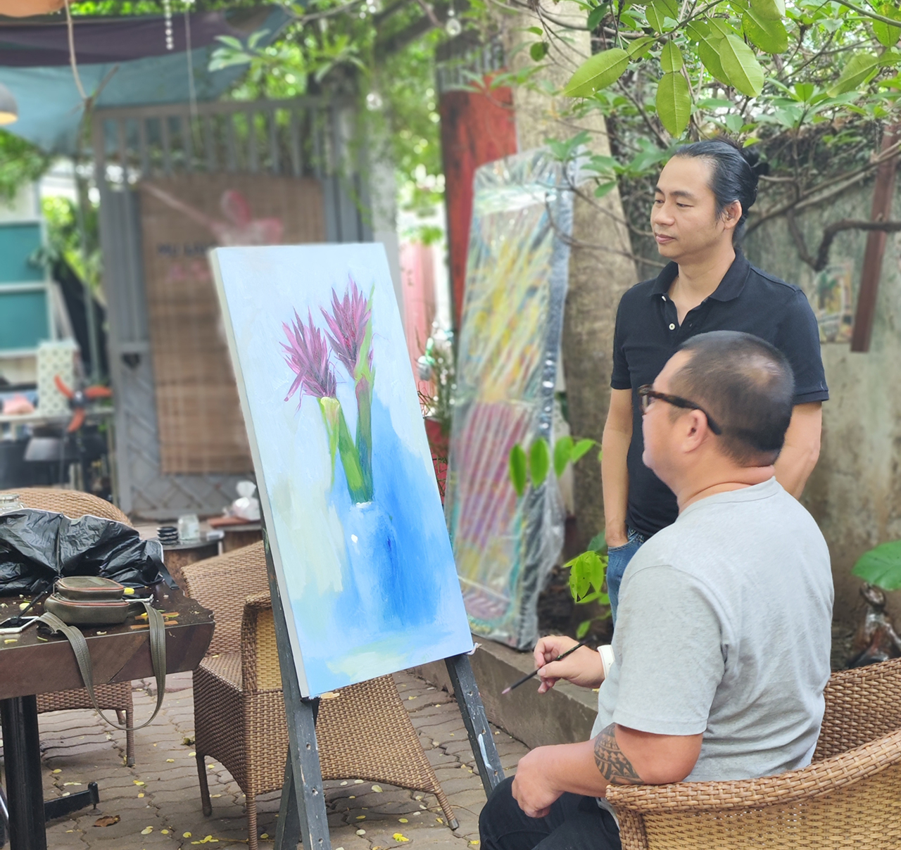Họa sĩ Nguyễn Ngọc Cường đang sáng tác tranh cho triển lãm, đứng bên cạnh là nhạc sĩ Lê Tuấn Đức. Triển lãm sẽ diễn ra vào 30-10-2023 tại không gian Mu Lala